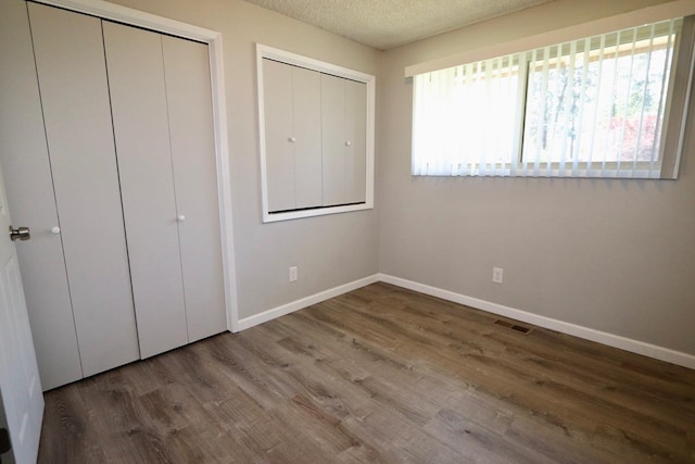 13703 E 31st Ave, Spokane Valley, WA 99216 - unfurnished bedroom with baseboards, wood finished floors, and a textured ceiling
