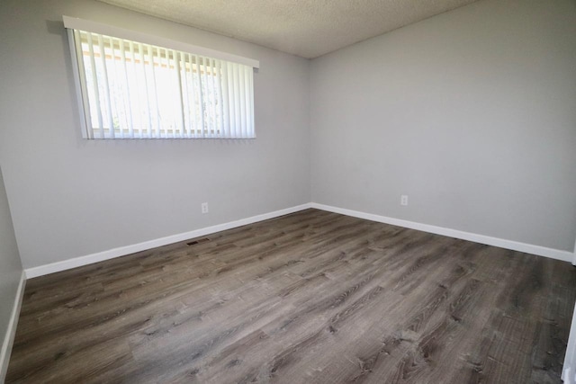 13703 E 31st Ave, Spokane Valley, WA 99216 - unfurnished room featuring dark wood-type flooring, baseboards, and a textured ceiling
