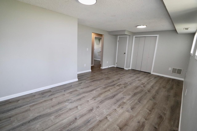 13703 E 31st Ave, Spokane Valley, WA 99216 - unfurnished bedroom with baseboards, a textured ceiling, wood finished floors, and a closet