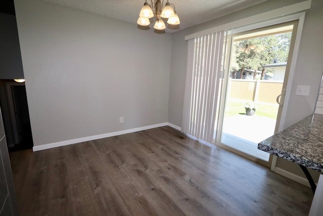 13703 E 31st Ave, Spokane Valley, WA 99216 - unfurnished dining area featuring a chandelier, dark wood-style flooring, a textured ceiling, and baseboards