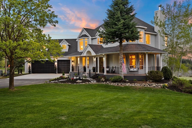 view of front of property featuring covered porch, concrete driveway, a front yard, and a garage