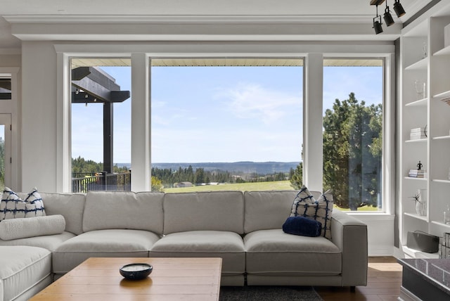 living room with dark wood-type flooring, crown molding, plenty of natural light, and baseboards