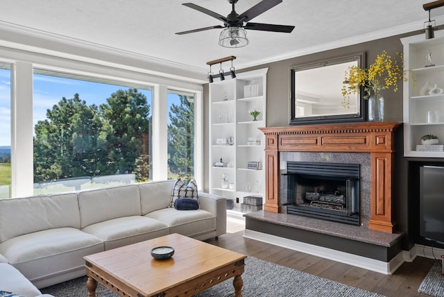 living room with ornamental molding, hardwood / wood-style flooring, ceiling fan, and a high end fireplace