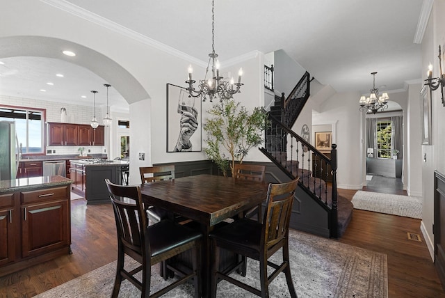 dining area with a chandelier, stairs, plenty of natural light, dark wood-style flooring, and crown molding