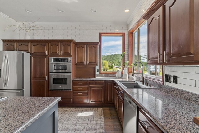 7406 S Deerview Ln, Spokane, WA 99223 - kitchen with stainless steel appliances, crown molding, a sink, light stone counters, and tasteful backsplash