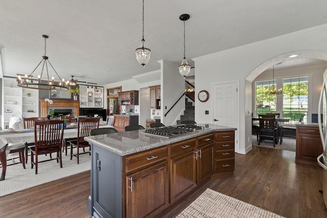 7406 S Deerview Ln, Spokane, WA 99223 - kitchen featuring a chandelier, stainless steel gas cooktop, crown molding, arched walkways, and dark wood-style flooring