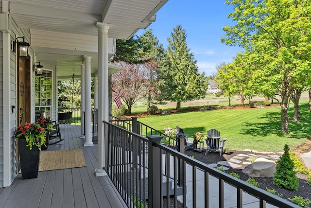 deck with a yard and covered porch
