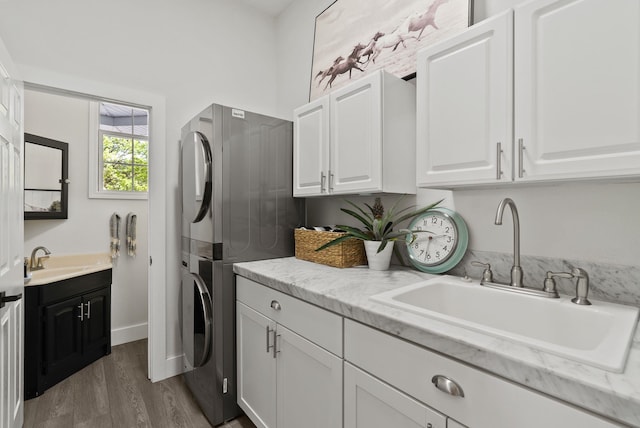 7406 S Deerview Ln, Spokane, WA 99223 - washroom with cabinet space, stacked washer and clothes dryer, and wood finished floors