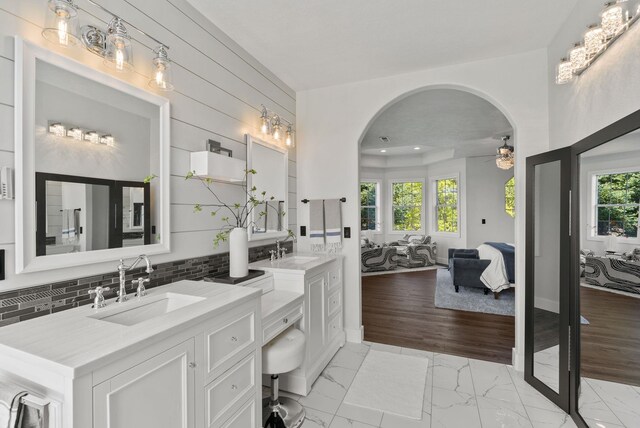 7406 S Deerview Ln, Spokane, WA 99223 - full bath with ensuite bath, a ceiling fan, decorative backsplash, marble look tile flooring, and two vanities