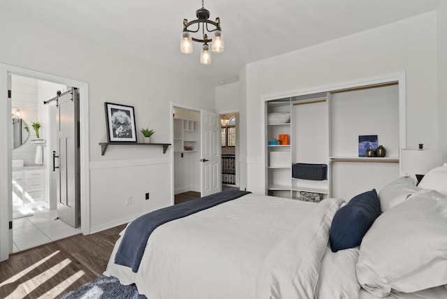 7406 S Deerview Ln, Spokane, WA 99223 - bedroom featuring a chandelier, a barn door, wood finished floors, and a closet