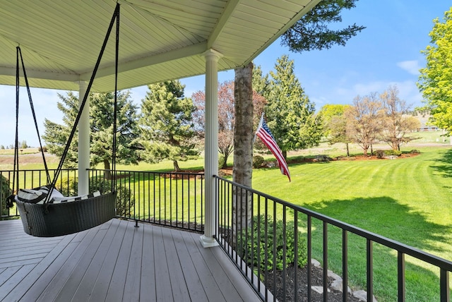 wooden deck featuring a lawn
