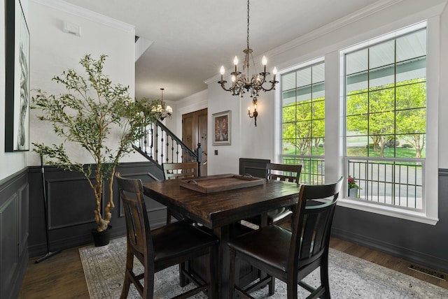 dining room with a chandelier, stairway, crown molding, wood finished floors, and plenty of natural light