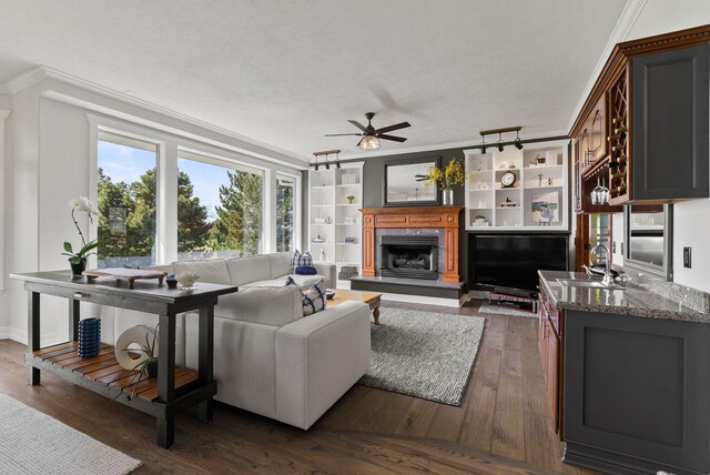 7406 S Deerview Ln, Spokane, WA 99223 - living room with a premium fireplace, crown molding, a ceiling fan, and dark wood-style flooring
