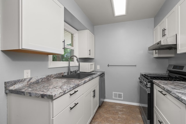 kitchen with appliances with stainless steel finishes, under cabinet range hood, a sink, baseboards, and white cabinets