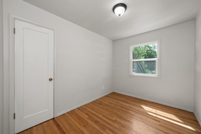 unfurnished room with light wood-type flooring and baseboards