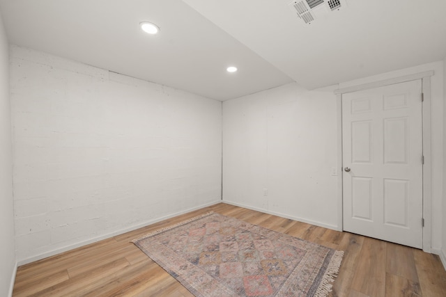 spare room featuring wood finished floors, baseboards, and recessed lighting