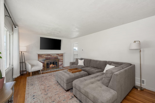 living room with wood finished floors, baseboards, and a fireplace