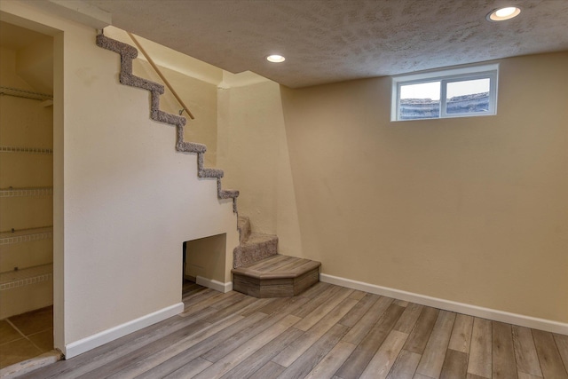 2410 W Upton Ave, Spokane, WA 99205 - below grade area featuring wood finished floors, baseboards, recessed lighting, stairway, and a textured ceiling