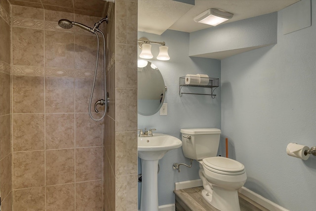 2410 W Upton Ave, Spokane, WA 99205 - bathroom featuring toilet, tiled shower, and baseboards