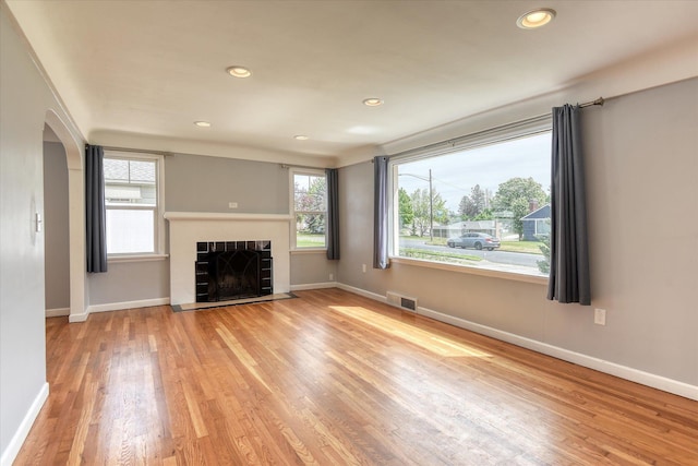 2410 W Upton Ave, Spokane, WA 99205 - unfurnished living room with arched walkways, wood finished floors, healthy amount of natural light, baseboards, and recessed lighting
