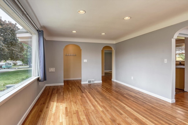 2410 W Upton Ave, Spokane, WA 99205 - empty room featuring arched walkways, recessed lighting, light wood finished floors, a sink, and baseboards