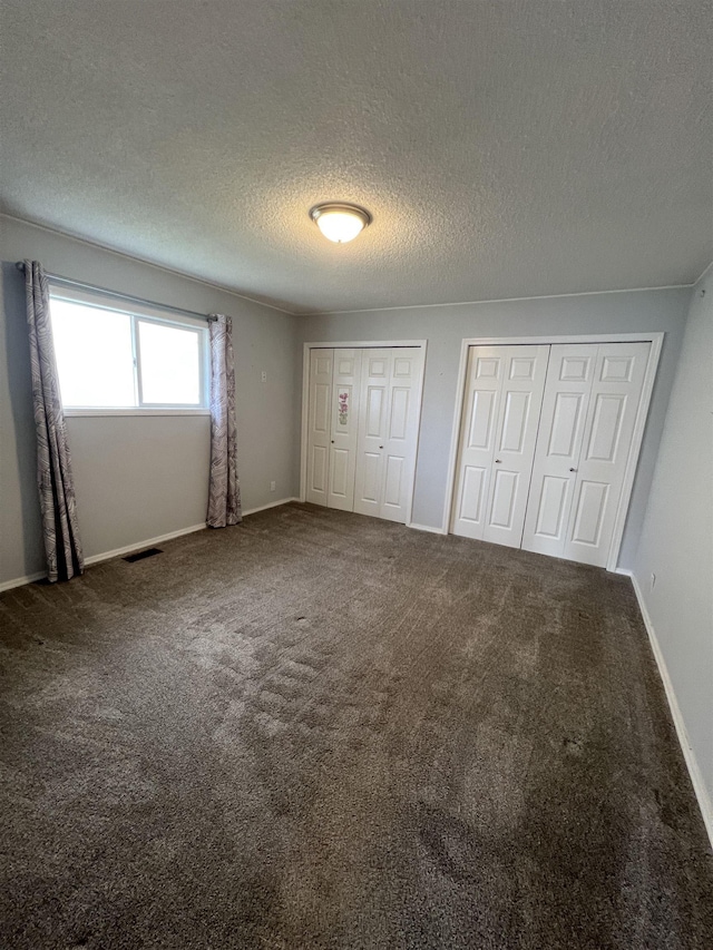 309 S Coal Creek Rd, Harrington, WA 99134 - unfurnished bedroom with multiple closets, a textured ceiling, carpet flooring, and baseboards
