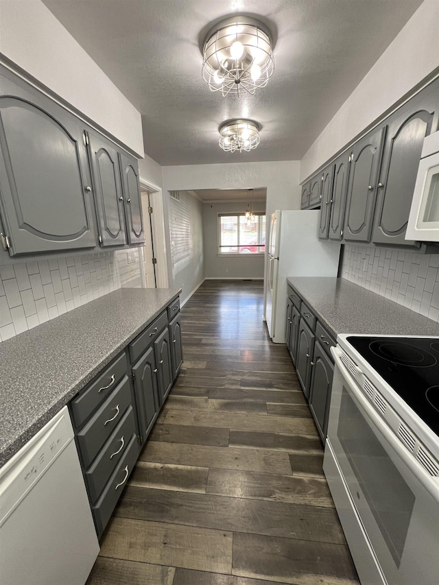 309 S Coal Creek Rd, Harrington, WA 99134 - kitchen featuring white appliances, dark wood finished floors, dark countertops, and decorative backsplash