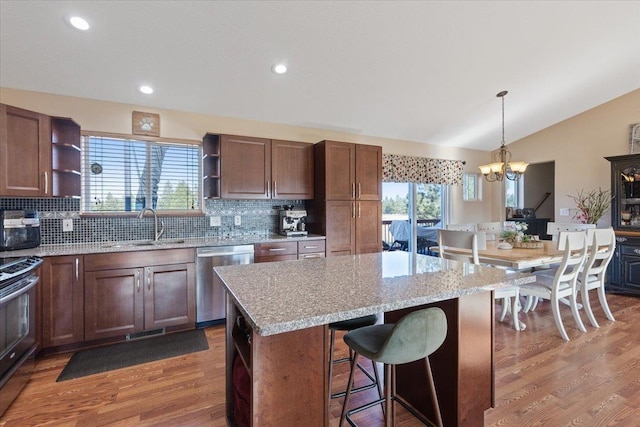 17206 W Buckboard Ave, Medical Lake, WA 99022 - kitchen with open shelves, stainless steel appliances, a sink, lofted ceiling, and wood finished floors