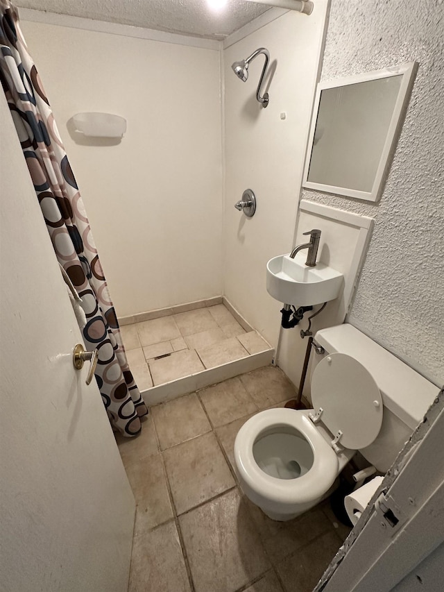 2211 W Rowan Ave, Spokane, WA 99205 - bathroom featuring toilet, tile patterned flooring, a shower with curtain, a sink, and a textured ceiling