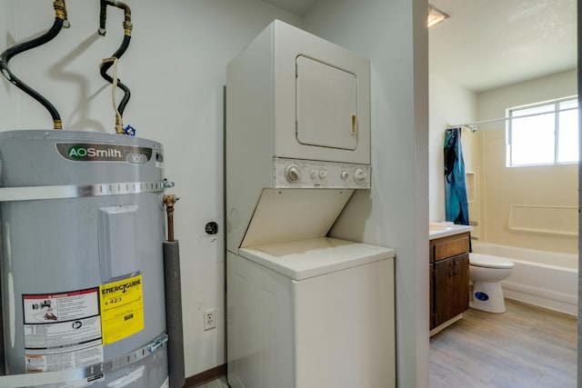 1514 3rd St, Cheney, WA 99004 - washroom with strapped water heater, stacked washer and clothes dryer, and light wood-style floors