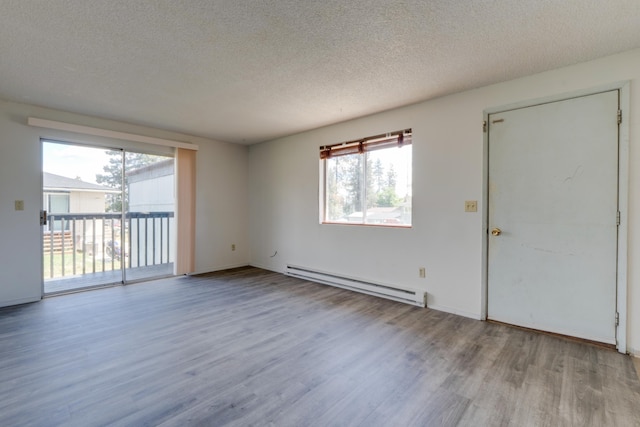 1514 3rd St, Cheney, WA 99004 - unfurnished living room with a baseboard radiator, wood finished floors, and a textured ceiling
