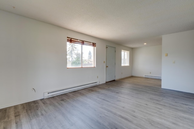 1514 3rd St, Cheney, WA 99004 - spare room with a baseboard heating unit, wood finished floors, a textured ceiling, and baseboards
