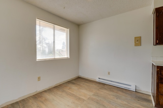 1514 3rd St, Cheney, WA 99004 - unfurnished dining area featuring a baseboard heating unit, light wood-type flooring, and a textured ceiling