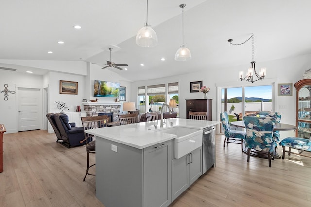 kitchen featuring dishwasher, a sink, lofted ceiling, gray cabinets, and ceiling fan
