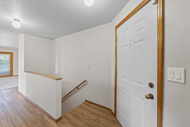 3716 S Alder Cir, Spokane, WA 99223 - corridor featuring an upstairs landing, a textured ceiling, wood finished floors, and baseboards