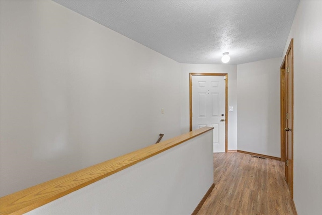 3716 S Alder Cir, Spokane, WA 99223 - hall featuring a textured ceiling, light wood finished floors, and baseboards