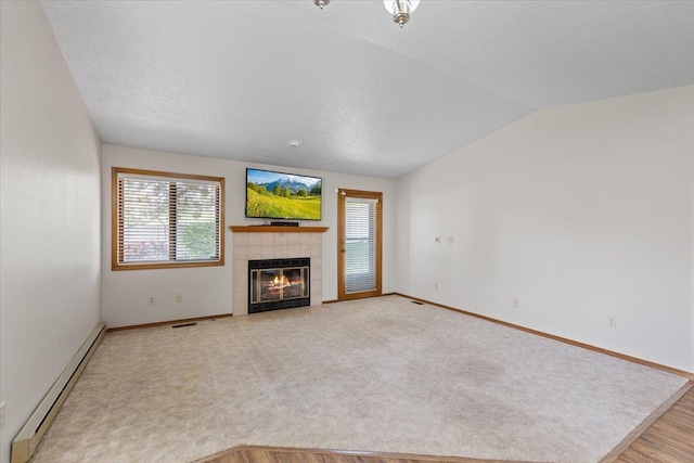 3716 S Alder Cir, Spokane, WA 99223 - unfurnished living room featuring baseboard heating, vaulted ceiling, plenty of natural light, a fireplace, and baseboards