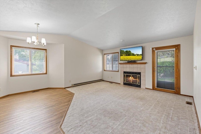 3716 S Alder Cir, Spokane, WA 99223 - unfurnished living room featuring a baseboard radiator, lofted ceiling, a chandelier, a fireplace, and a textured ceiling