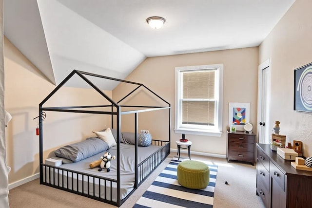 bedroom with light colored carpet, baseboards, and vaulted ceiling