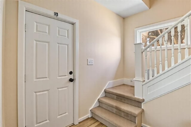 entrance foyer featuring stairs, baseboards, and light wood-style flooring
