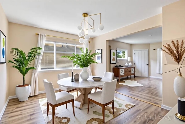 dining area with baseboards and light wood-style flooring