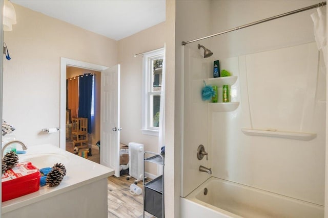 bathroom with shower / bath combination with curtain, wood finished floors, and vanity