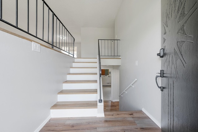 stairs featuring wood finished floors and baseboards