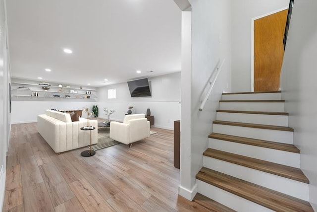 staircase with wood finished floors and recessed lighting