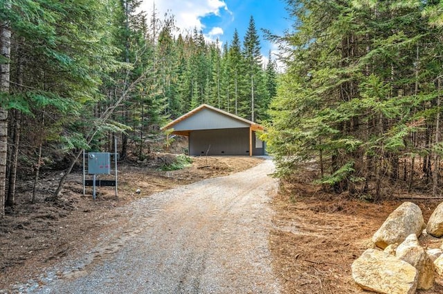 4821 Coyote Trl, Newport, WA 99156 - garage featuring driveway, a forest view, and a carport