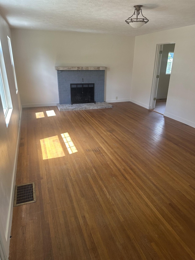 2304 W Glass St, Spokane, WA 99205 - unfurnished living room featuring wood finished floors, a brick fireplace, and baseboards