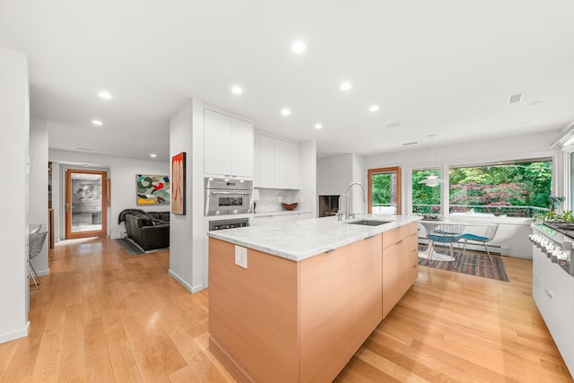 2127 S Helena St, Spokane, WA 99203 - kitchen featuring a sink, modern cabinets, recessed lighting, light wood-style floors, and light stone countertops
