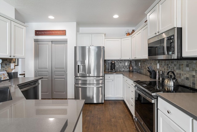 7405 E 13th Ct, Spokane, WA 99212 - kitchen featuring stainless steel appliances, backsplash, white cabinets, dark wood finished floors, and recessed lighting