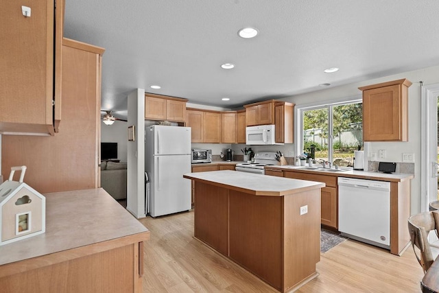 1626 5th St, Cheney, WA 99004 - kitchen featuring white appliances, light countertops, light wood-style flooring, a sink, and a center island
