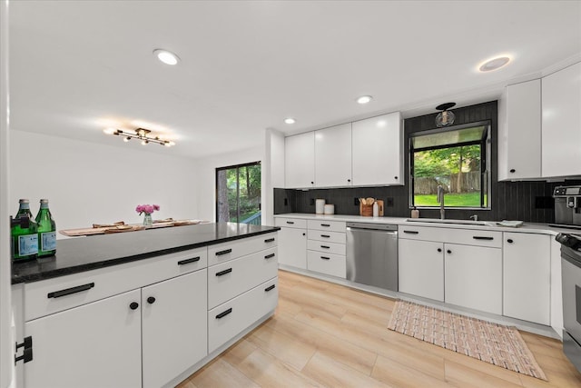 kitchen with dishwasher, a sink, tasteful backsplash, white cabinets, and recessed lighting